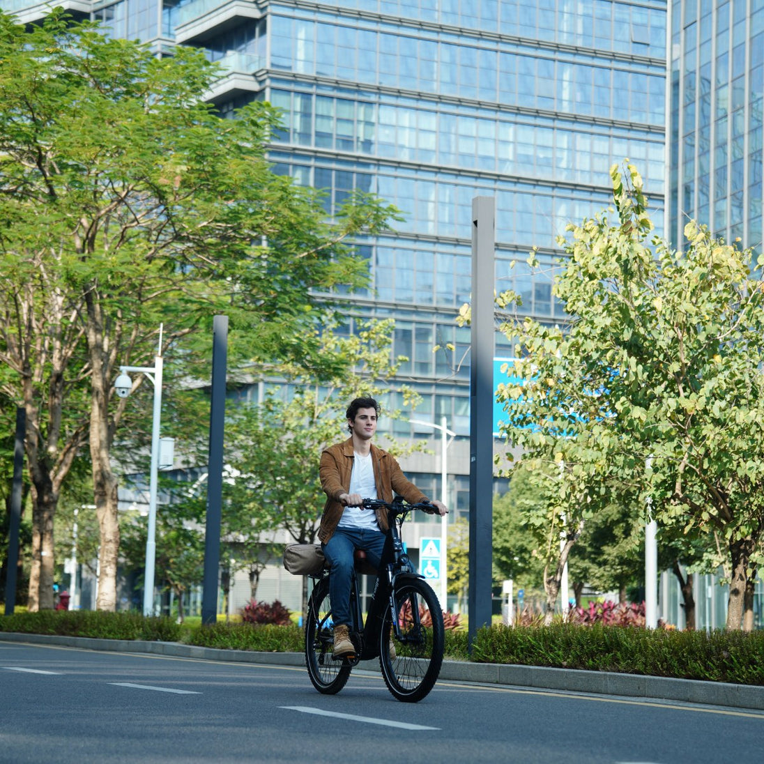 Man riding a Freego City Flow A1 Electric Bike on a city street with modern buildings and trees in the background