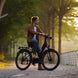 Man riding an Freego City Flow A1 Electric Bike on a path with trees in the background
