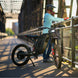Person with a Freego X2 Pro dirt ebike on a bridge during sunset