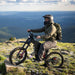 Person riding a Freego X2 Pro dirt ebike on a mountain with a scenic view in the background