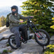 Man riding an Freego X2 Pro dirt ebike in a mountainous area with trees and rocks.